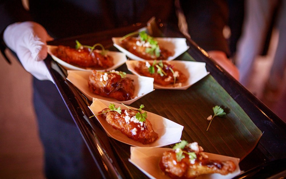 A tray of chef-plated bites being served at a Founder's Plateau evening
